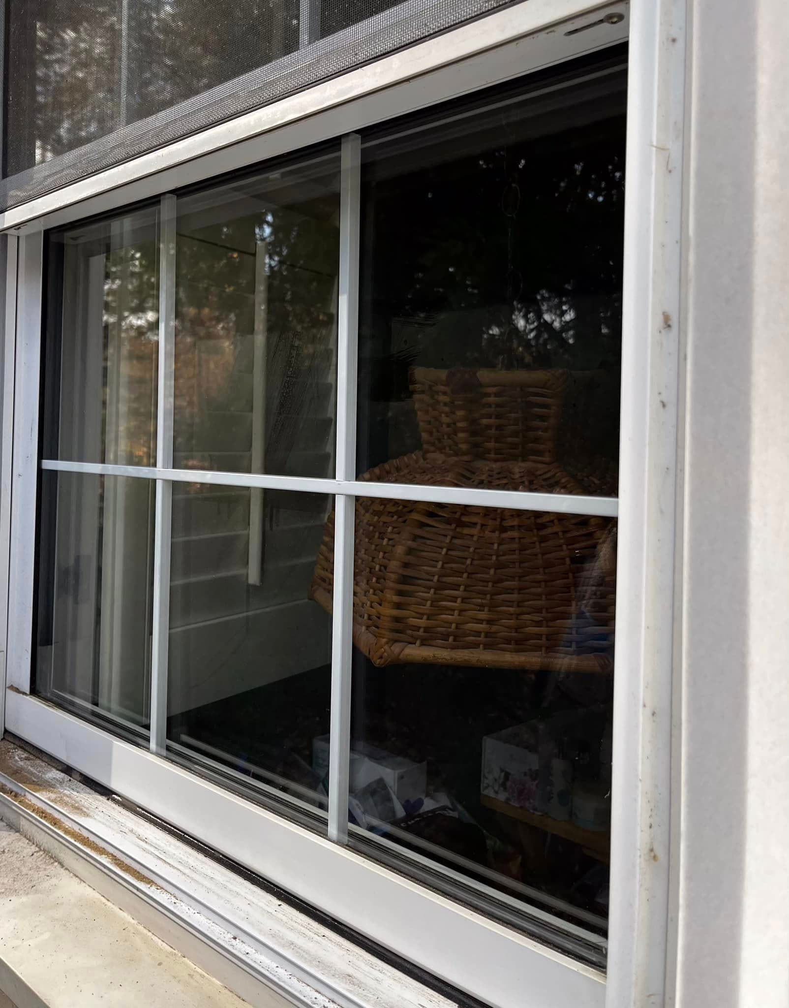 Window with a grid design showing a woven basket inside the room. Natural light is visible.