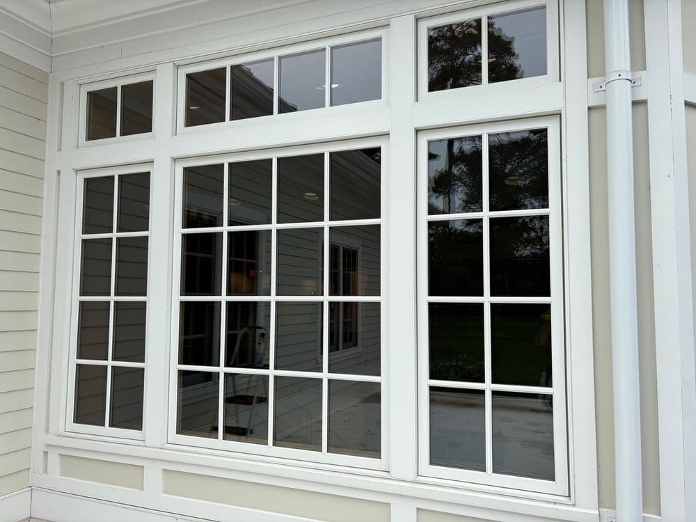 White grid-patterned window with reflective glass, enhancing natural light in a modern home.